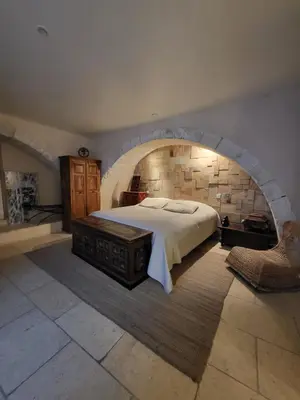 a bedroom with a large bed in a brick wall at Gite A.M Hoche in Lançon-Provence