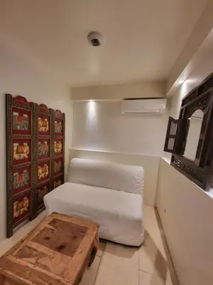 a room with a white bed and a wooden table at Gite A.M Hoche in Lançon-Provence