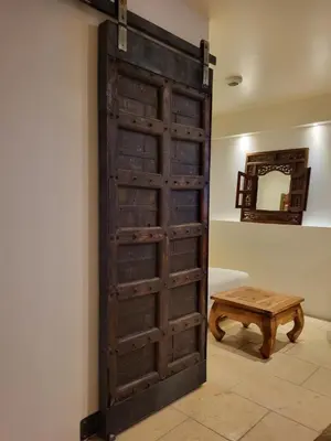 an old wooden door in a room with a wooden stool at Gite A.M Hoche in Lançon-Provence