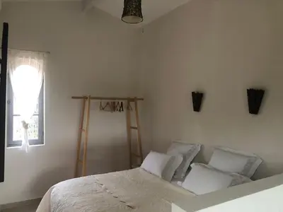 a bedroom with a bed with white pillows and a window at le Mas des Pignes -adults only in Aix-en-Provence