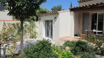 a small white house with a table and a chair at Studio A Grans in Grans