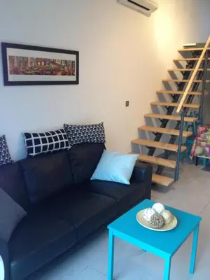 a living room with a black couch and a blue table at Studio A Grans in Grans