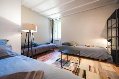 a bedroom with two beds and a table and a lamp at Su Lei Campanes in Lauris