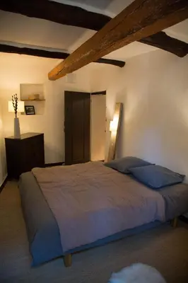 a bedroom with a large bed with blue pillows at Su Lei Campanes in Lauris