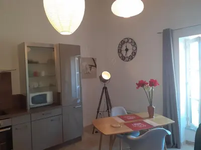 a kitchen with a table and a clock on the wall at L'ARCHIMBAUDE in Pertuis
