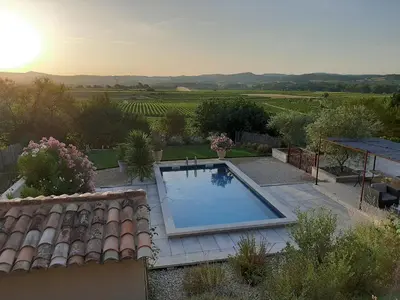 a swimming pool in a garden with a view of a vineyard at L'ARCHIMBAUDE in Pertuis