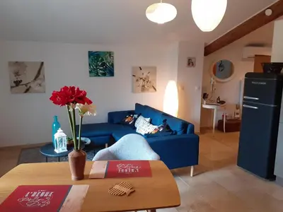 a living room with a blue couch and a table at L'ARCHIMBAUDE in Pertuis