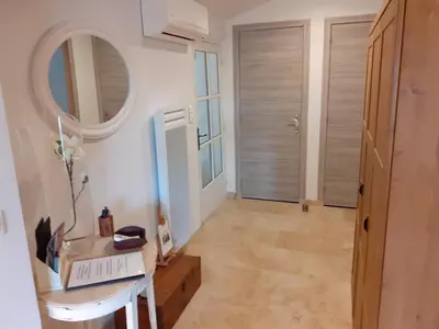 a hallway with a table and a mirror and a door at L'ARCHIMBAUDE in Pertuis