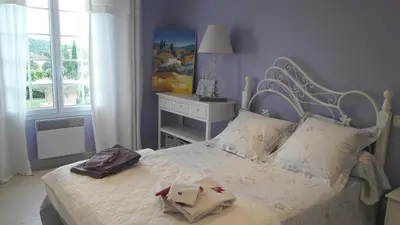 a bedroom with a bed with white sheets and a window at Villa Eglantine in Caumont-sur-Durance