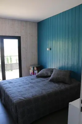 a bedroom with a bed with a blue wall at Belle villa en Provence in Lançon-Provence