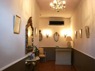 a hallway with a mirror and a table and a chandelier at Hôtel Le Siècle in Mazan