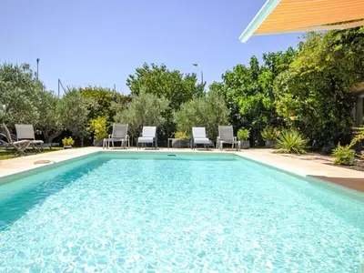 a swimming pool with chairs in a backyard at Villa Les Angevines by Interhome in Morières-lès-Avignon