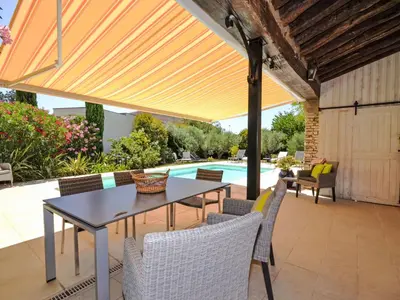 a patio with a table and chairs and a pool at Villa Les Angevines by Interhome in Morières-lès-Avignon