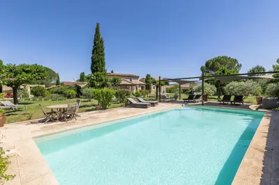 a swimming pool in a yard with a table and chairs at Mas Oréa côté piscine in Gordes