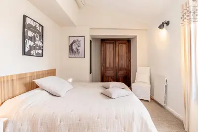 a bedroom with a large white bed with two pillows at Mas Oréa côté piscine in Gordes