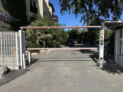 a gate in the middle of a street at Hotel Les Nevons in LʼIsle-sur-la-Sorgue