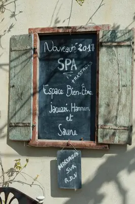 a chalkboard sign on the side of a wall at Gite des Carmes and Spa in Le Thor