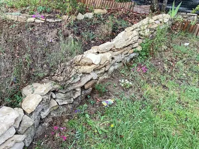 a pile of rocks and a meter in the grass at Maison charmante à Vachères avec vue sur la montagne in Vachères