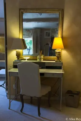 a desk with a lamp and a chair in front of a mirror at Domaine de Mejeans - Teritoria in Alleins