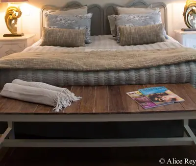 a bed with a table with a book on it at Domaine de Mejeans - Teritoria in Alleins