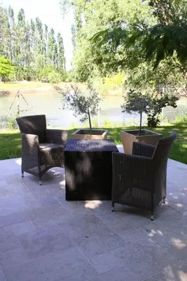 a patio with three chairs and a table with two trees at Domaine de Mejeans - Teritoria in Alleins