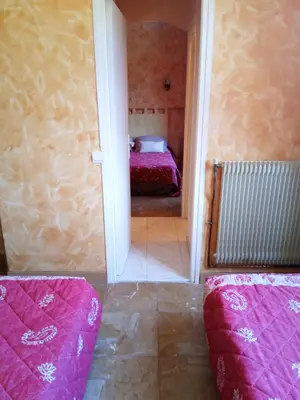 a room with a bed in a room with pink sheets at Hotel Font De Lauro in Saumane-de-Vaucluse