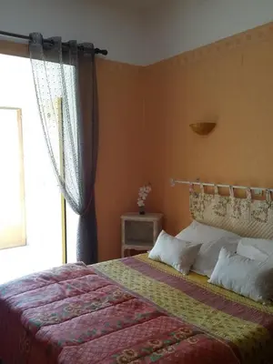 a bedroom with a large bed with a window at Hotel Font De Lauro in Saumane-de-Vaucluse