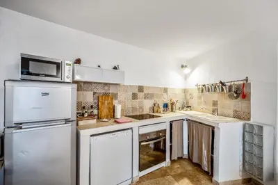 a kitchen with a refrigerator and a microwave at Maison de village in Bonnieux