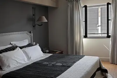 a bedroom with a large bed with a window at La Maison Sur La Sorgue - Esprit de France in LʼIsle-sur-la-Sorgue