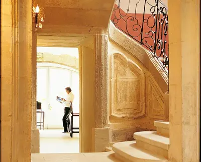 a man standing in the hallway of a building at La Maison Sur La Sorgue - Esprit de France in LʼIsle-sur-la-Sorgue