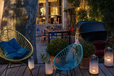 a patio with two chairs and a grill with a table at La Maison Sur La Sorgue - Esprit de France in LʼIsle-sur-la-Sorgue