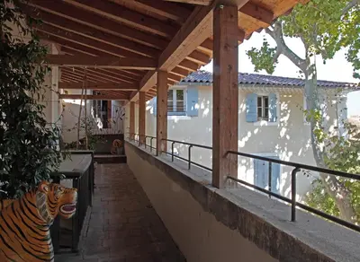 a tiger statue sitting on the porch of a house at La Maison Sur La Sorgue - Esprit de France in LʼIsle-sur-la-Sorgue