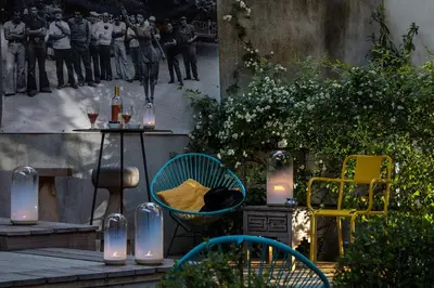 a patio with a table and chairs and candles at La Maison Sur La Sorgue - Esprit de France in LʼIsle-sur-la-Sorgue