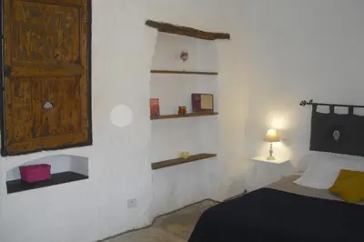 a bedroom with a bed and shelves on the wall at Lou mas li Pitchoun 