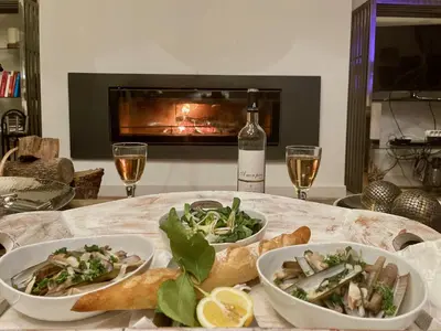 a table with two bowls of food and a bottle of wine at Mas La Bellevue in Murs