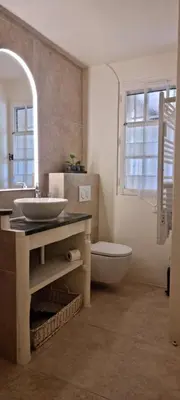 a bathroom with a sink and a toilet and a mirror at Le Jas des Parpaillous in LʼIsle-sur-la-Sorgue