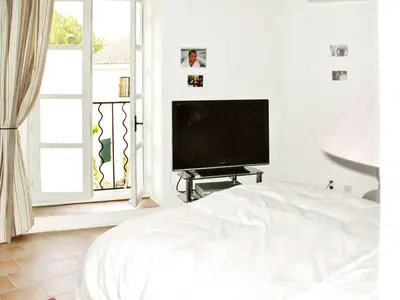 a bedroom with a bed and a flat screen tv at Maison de charme à Mollégès avec piscine privée in Mollégès