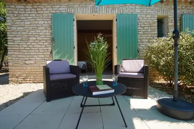 a patio with two chairs and a table and an umbrella at Mas Val-Chênaie Gordes in Gordes