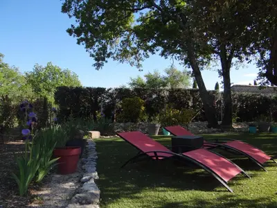 two red benches sitting in the grass in a yard at Mas Val-Chênaie Gordes in Gordes