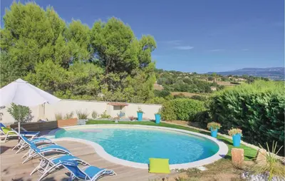 a swimming pool with lounge chairs at 4 Bedroom Beautiful Home In Goult in Goult