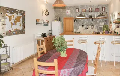 a kitchen with a table and a kitchen with a refrigerator at 4 Bedroom Beautiful Home In Goult in Goult