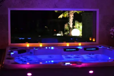 a bath tub in front of a window with purple lights at L instant Magique in Beaumont-de-Pertuis