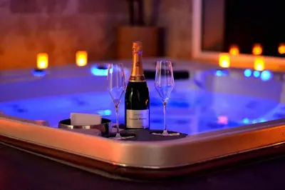 a bottle of wine and two glasses on a tray next to a swimming pool at L instant Magique in Beaumont-de-Pertuis