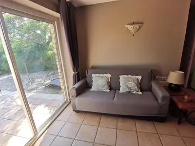a living room with a couch and a sliding glass door at Bastidon Provencal in Gordes