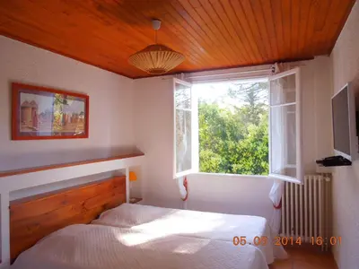 a bedroom with a bed and a window at Villa - La Luberonne in Lourmarin