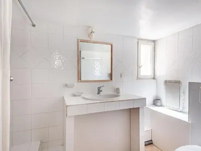 a white bathroom with a sink and a mirror at Apartment Mireio by Interhome in Lambesc