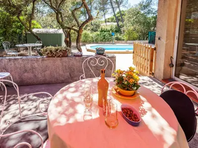 a table with a bottle of wine and flowers on a patio at Apartment Mireio by Interhome in Lambesc