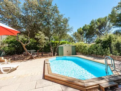 a swimming pool in a yard with an umbrella at Apartment Mireio by Interhome in Lambesc