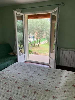 a bedroom with a bed and a sliding glass door at Ll POULIDETTO in Lioux