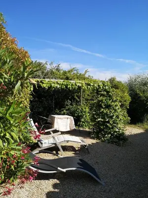 a picnic table and a chair in a garden at The Neame House in Bédoin
